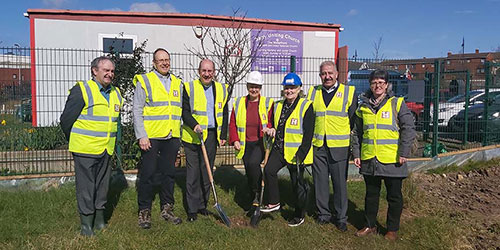 Group on building site with spades